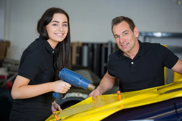 Car wrappers using heat gun to prepare vinyl foil