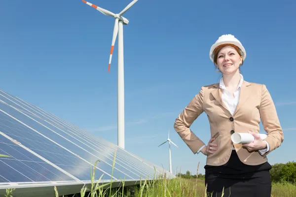 Engineer  posing with wind turbine and solar panels