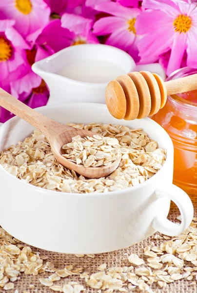 Oatmeal, honey, milk jug and flowers