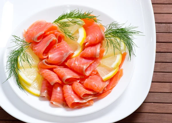 Sliced salted salmon served with lemon