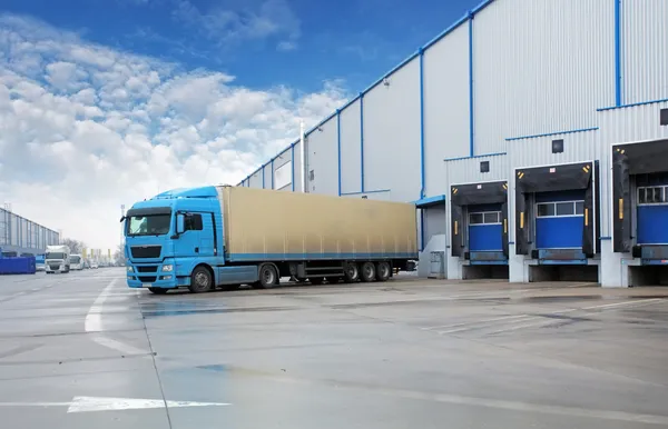 Unloading cargo truck at warehouse building