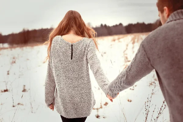 Couple walking in cold field
