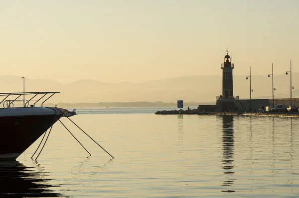 Lighthouse and yacht at sunrise, France