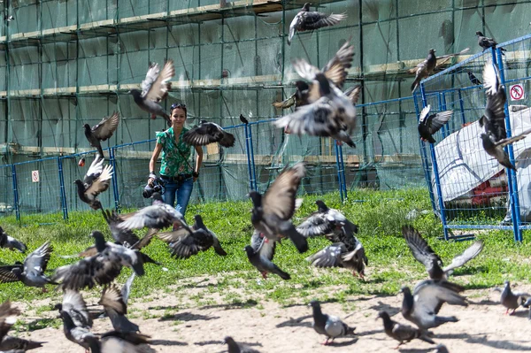 Tourist and pigeons at Trinity Sergius Lavra in Sergiev Posad. Russian Federation