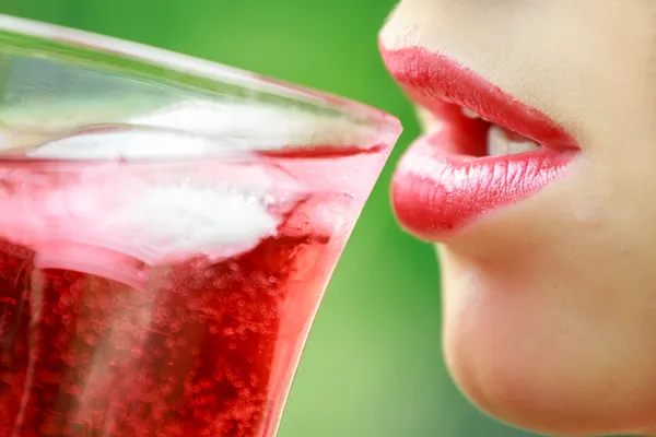 Woman with red lips drinking a cocktail