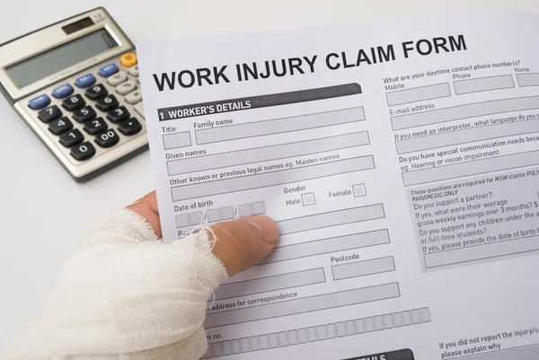 Hurted hand holding a work injury claim form