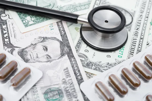 Stethoscope and pills and US money, concept of health care reform