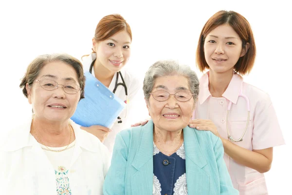 Smiling Asian medical staff with old women