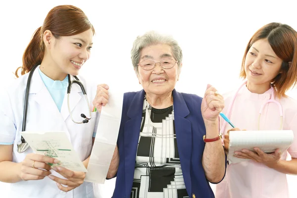 Smiling Asian medical staff with old woman