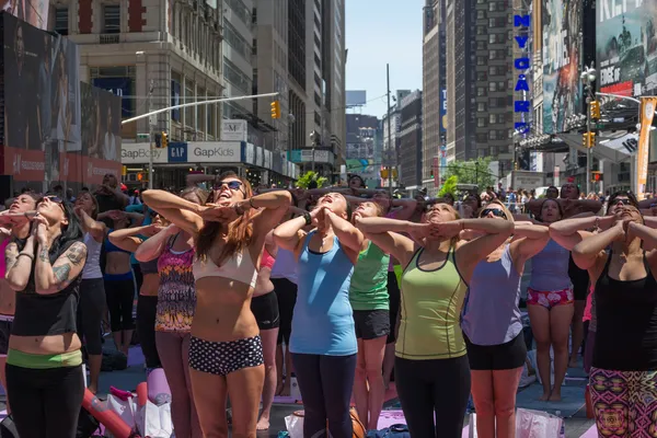 Thousands of New Yorkers practicing yoga in Times Square.