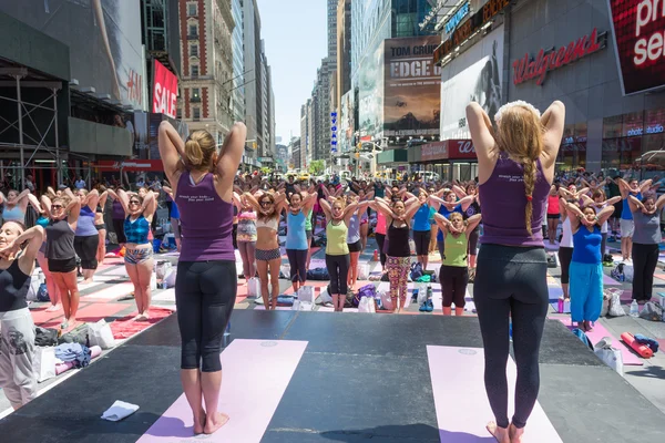 Thousands of New Yorkers practicing yoga in Times Square.