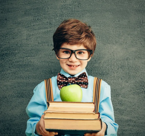 Little boy with books and apple