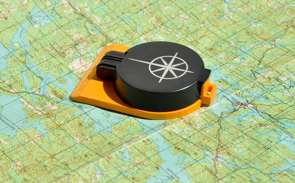 Compass lies on a topographic map.