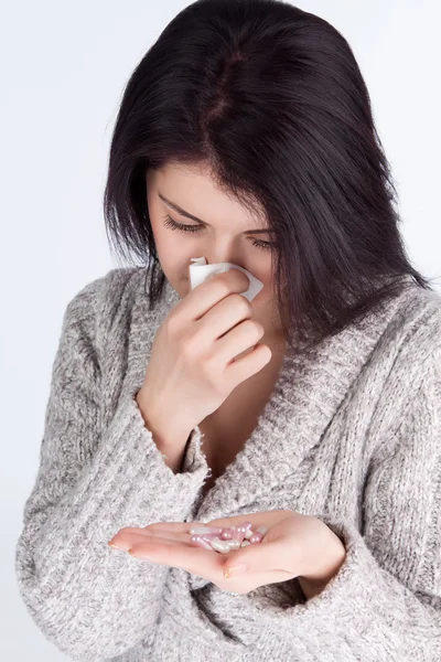 Girl holding a tablet covers and nose with a tissue