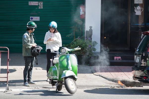 Two with motorbike next to fire