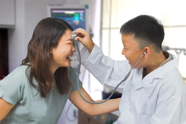 Boy acts like a doctor check up his mother