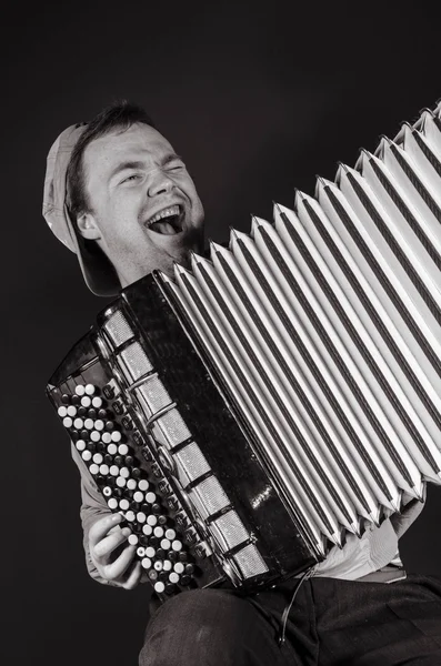 Russian man plays the accordion and sings