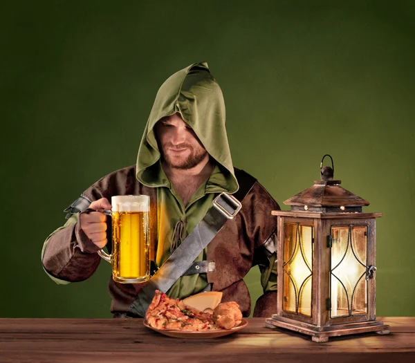 Medieval man in a tavern with a beer on the vintage background