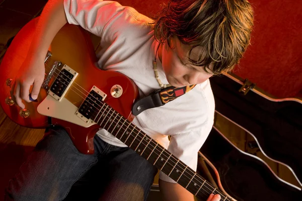 Boy plays electric guitar