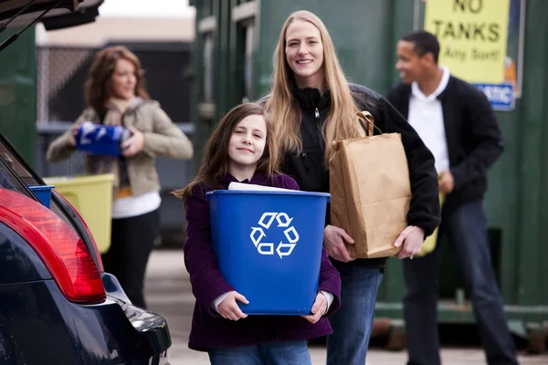 Volunteer employee helping girls at recycling center