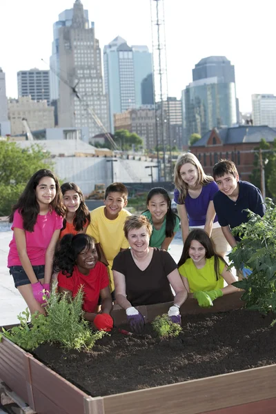 Children of different ethnicities planting with an adult