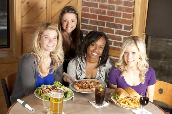 Adult roup of women friends eating together at a restaurant
