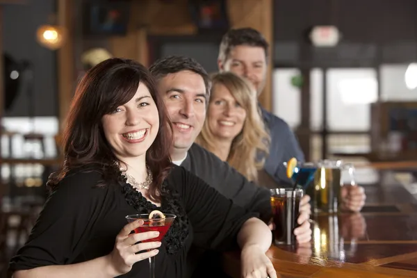 Adult caucasian couples enjoying a night out with friends at a restaurant bar.