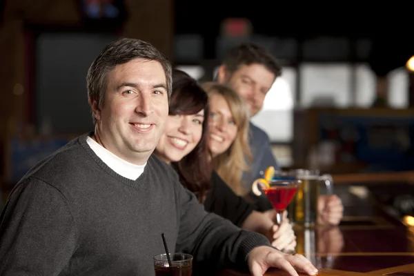 Adult aucasian couples enjoying a night out with friends at a restaurant bar.