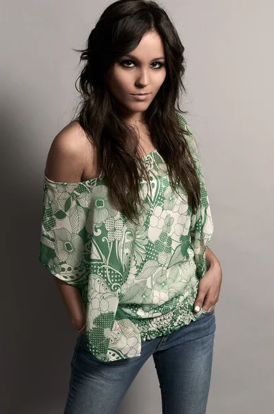 Fashion studio shot of beautiful woman with jeans and green blou