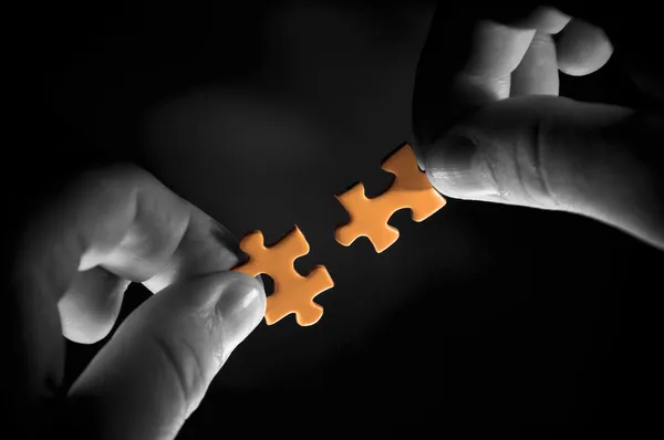 Puzzle in hand on a black background