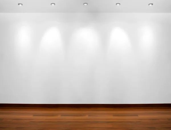 Empty white wall with 3 spot lights and wooden floor