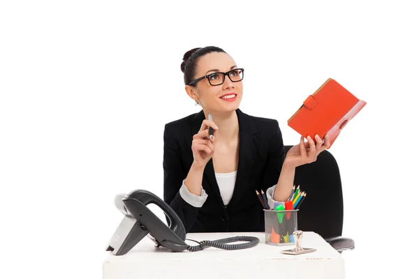 Businesswoman sitting in office chair and writing in notebook
