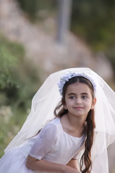 Young girl outside in a holy communion dress