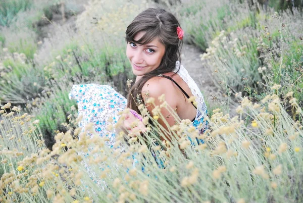 Girl with long dark hair in a long blue dress  on the beach