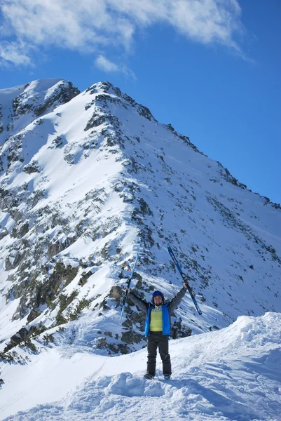 Athlete skier posing on mountain resort of Bansko in Bulgaria on a sunny winter day.