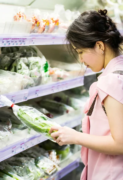 Woman choosing chinese cabbage at supermarket