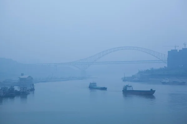 Bridge crossing the river, heavy fog and haze