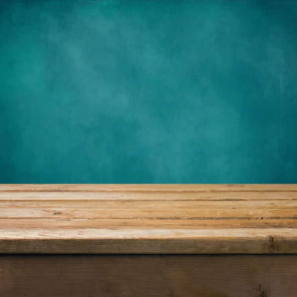 Background with wooden table and grunge blue wall