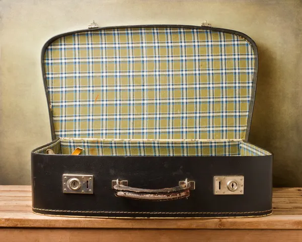 Empty vintage open suitcase on wooden table