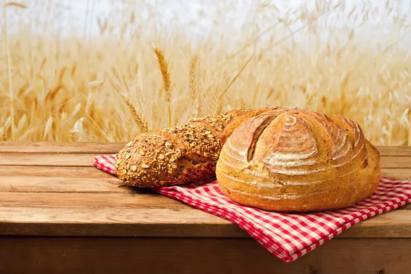 Fresh bread on tablecloth on wooden vintage table