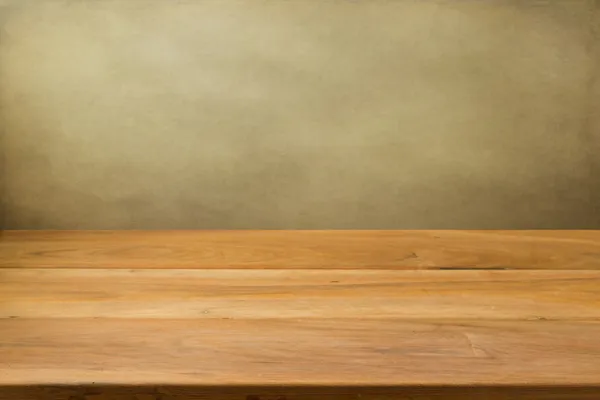 Empty wooden table over grunge background.