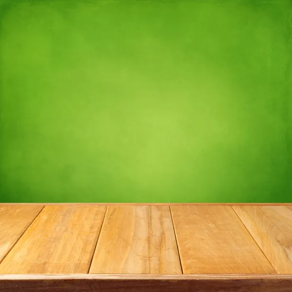 Summer background with wooden empty table and green grunge wallpaper