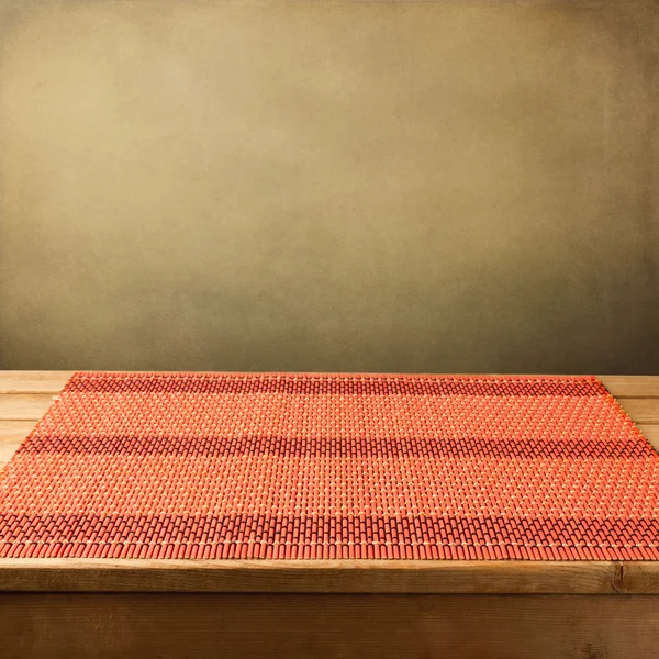 Bamboo tablecloth on wooden table over grunge background