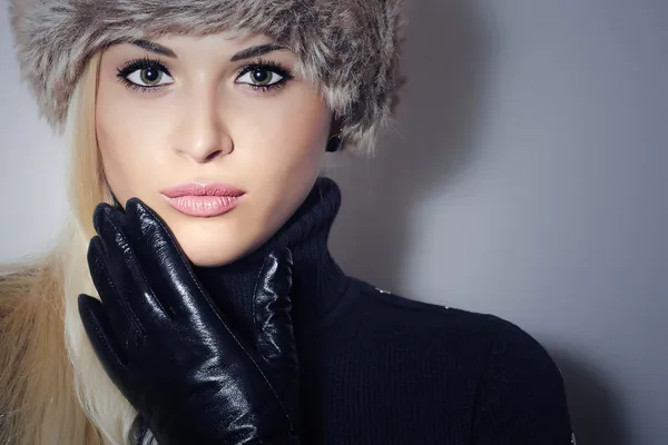 Beautiful Blond Young Woman in Fur Hat. Beauty Girl in Black Leather Gloves. Winter Fashion. Pretty Model