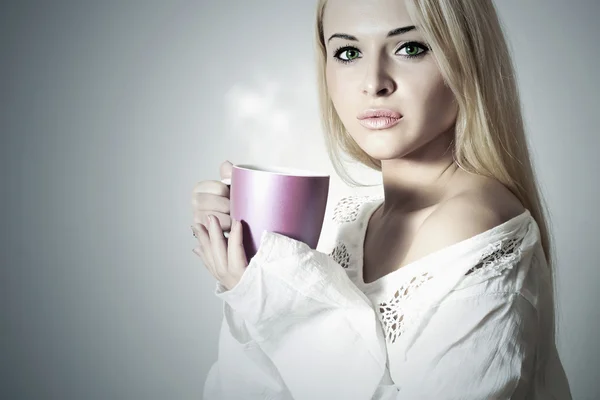 Beautiful blond woman drinking Coffee. Cup of tea. Hot drink. Morning