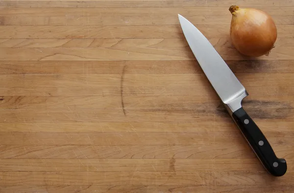 Knife and Onion on Cutting Board