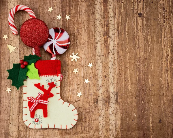 Christmas decorations and sock on wood background