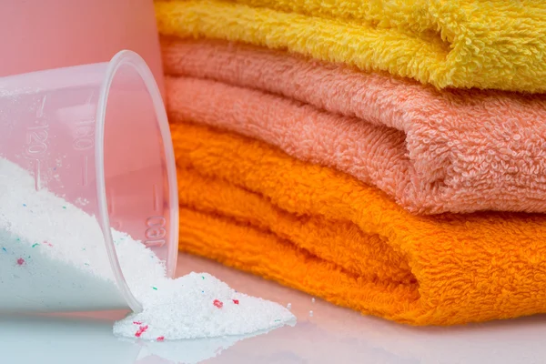 Detergent for washing machine in laundry with towels in the white background.