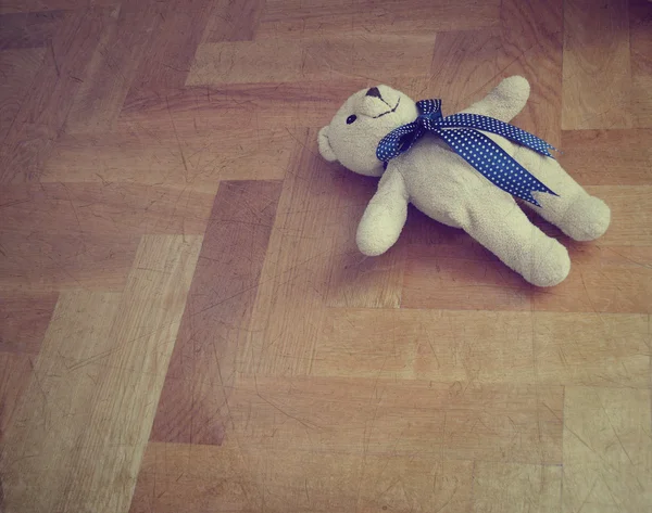 Lonely teddy bear on the floor - retro styled