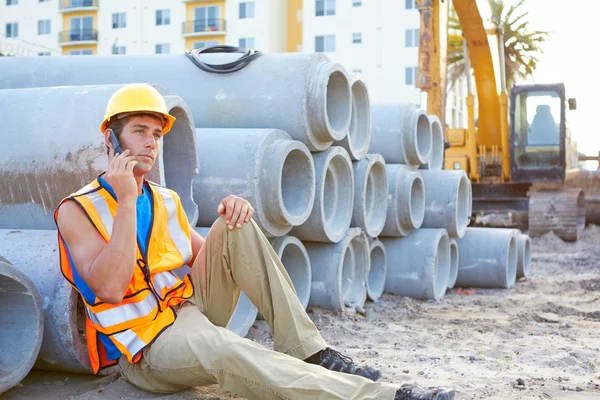 Young construction worker on cell phone
